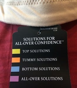 Clothing tag for shapewear labeled “Solutions for All-Over Confidence,” with color-coded categories including tummy, bottom, and all-over solutions.